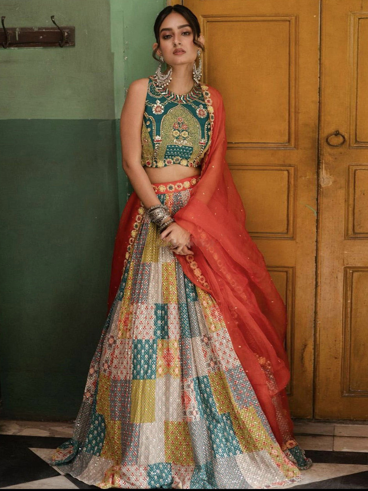 Buy a vibrant Navratri lehenga for women featuring printed silk, sequin embroidery, cancan, canvas, Rama-Rust blouse and fully stitched Organza dupatta.