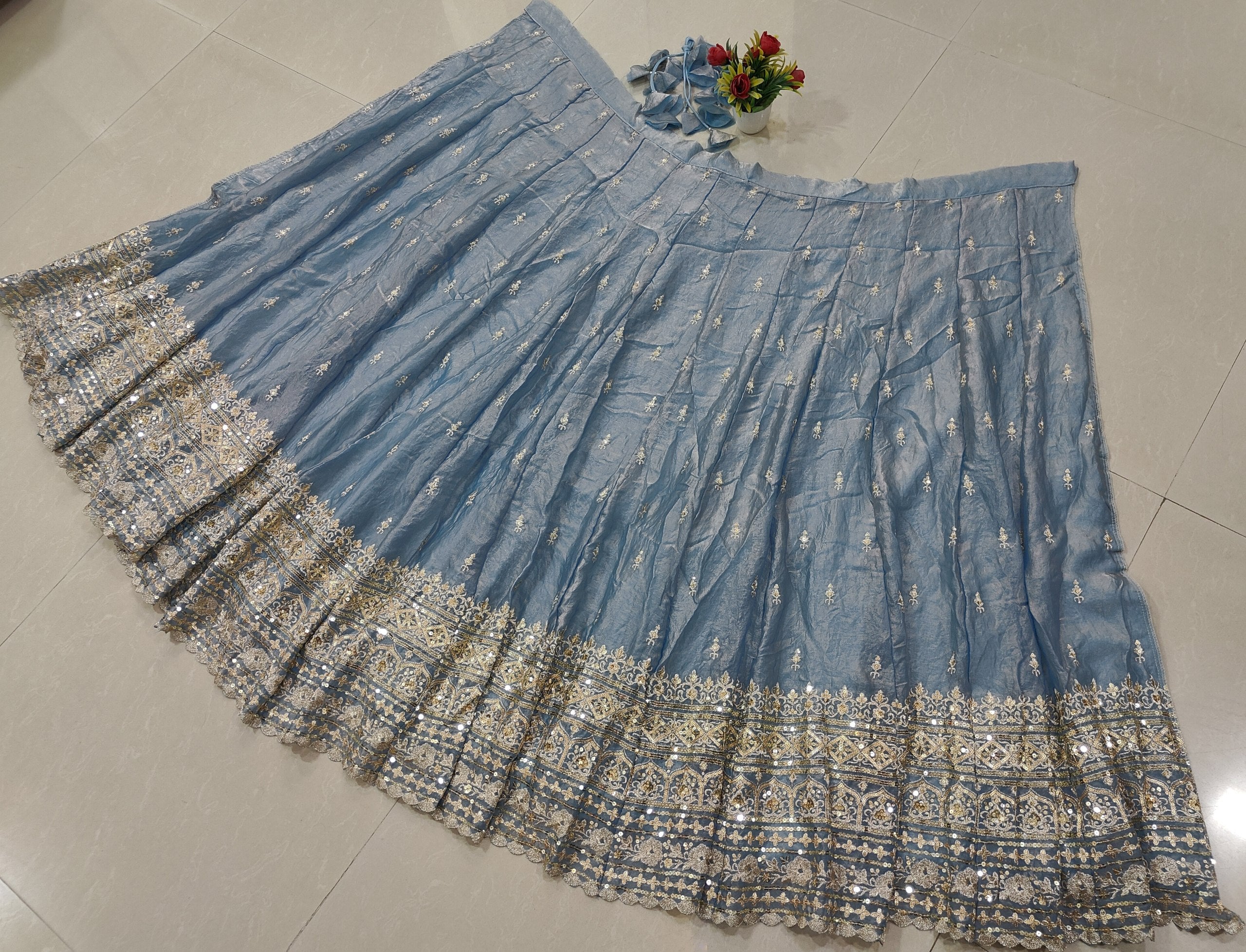 Style this dusty blue lehenga dress for weddings, receptions and festive events with Gold Shading Silk, embroidered sleeves and handmade tassels.