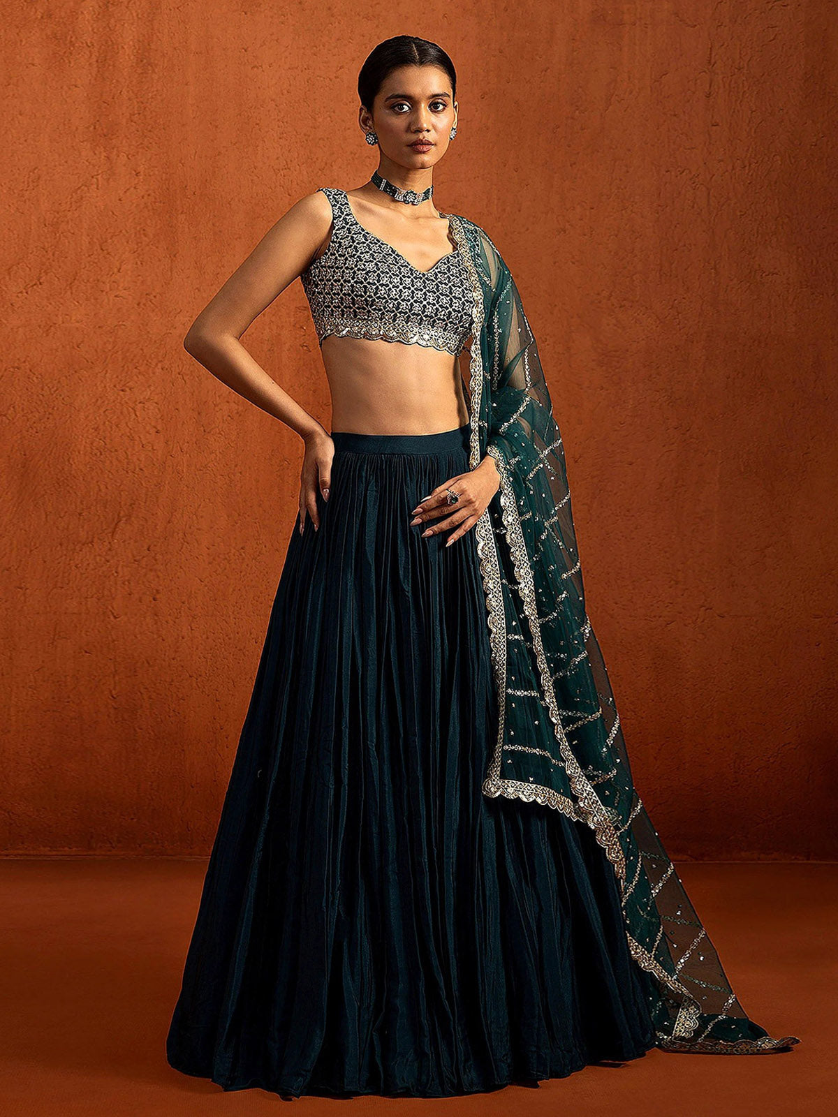 Buy a designer silk lehenga choli featuring Chinon Silk fabric, rich Zari and sequin embroidery, grand 5.80M flair and an unstitched blouse.