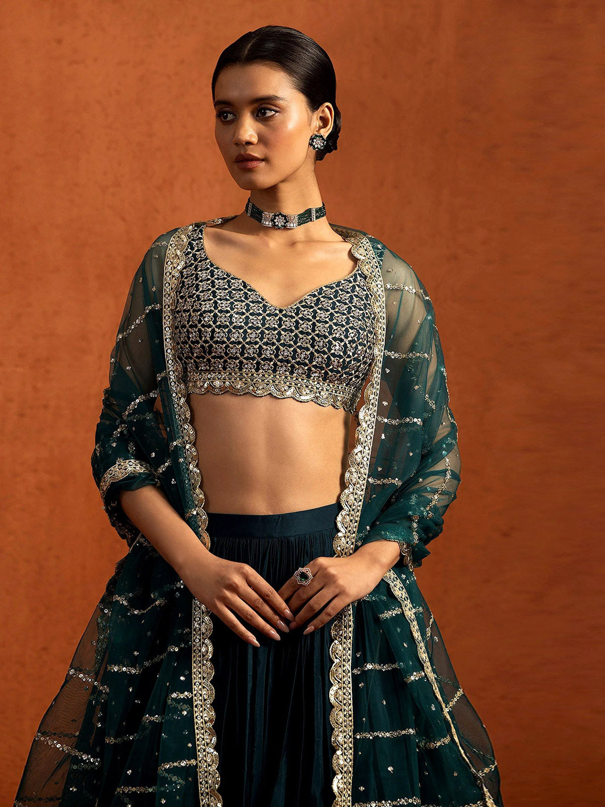 Buy a designer silk lehenga choli featuring Chinon Silk fabric, rich Zari and sequin embroidery, grand 5.80M flair and an unstitched blouse.