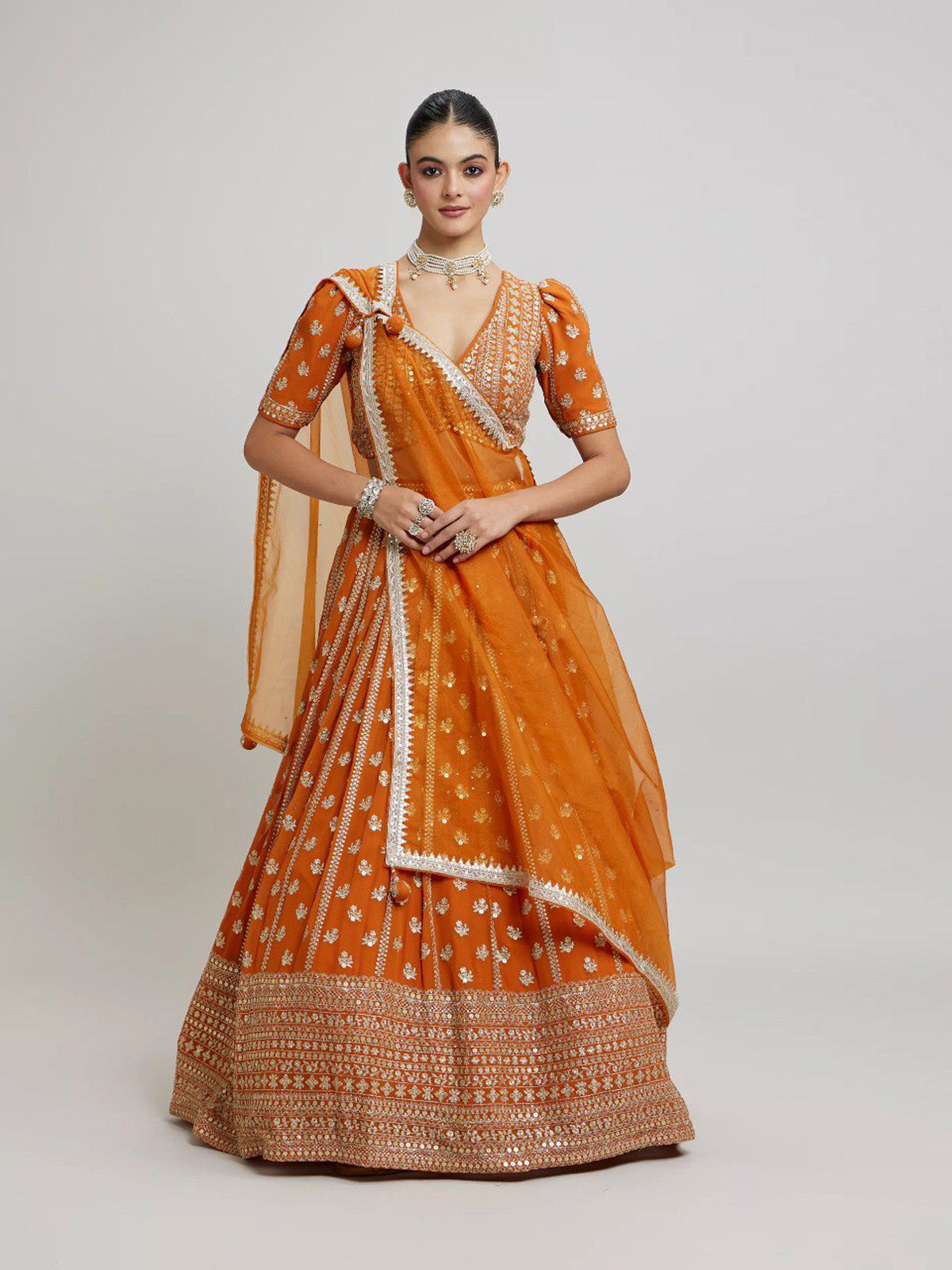 Discover FEALDEAL designer orange wedding lehenga choli with matte sequins, zari embroidery and premium faux georgette dupatta.